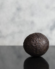 isolated avocado on dark granite with white granite background	