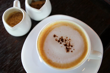 hot cappuccino coffee on wooden table