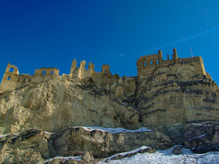 A castle on top of the mıountain.The The view of snowy mountains and peak with blue sky and clouds