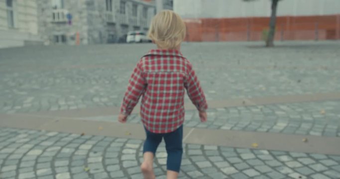 Little toddler running in the street of old city