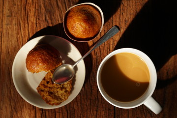 Hot coffee on wooden table, The best instant coffee served with banana cake. Porcelain coffee cup on table with dessert, Selective focus and free space for text. Industrial food and drink concept.