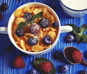 Corn Flakes with fresh berrys cereal in a bowl and glass with milk. Morning breakfast.