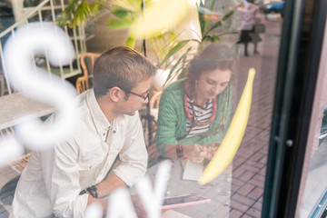 Obraz premium Breakfast together. Top view of cute loving couple having breakfast sitting near window in cafeteria together