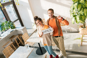 Stylish couple. Top view of stylish beautiful couple standing in their own restaurant opening it