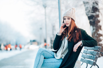 Young  woman smiling with smart phone and winter landscape .