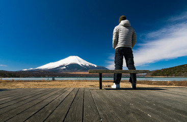 Traveller stand on lake side with cold wheather and looking to Fuji mountain