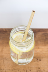Lemon water and bamboo drinking straw.