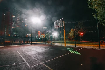 Fotobehang Illuminated basketball playground with red pavement, modern new basketball net and lens flares on background.  © Aleksander