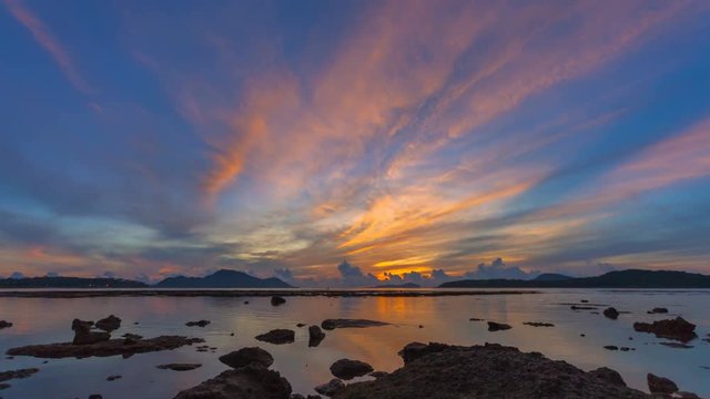 time lapse scenery beautiful sunrise red sky changing to golden color. water in the sea is reduced to see the coral..Coral reefs emerge from the sea during reduced water.