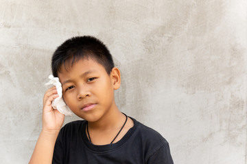 Asian boy wipe the sweat on his face with tissue.