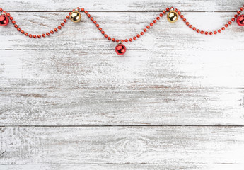 Fototapeta na wymiar Old wooden Christmas background. Garlands and red baubles. Xmas greeting card. Top view. Space for your text. Gold ball.