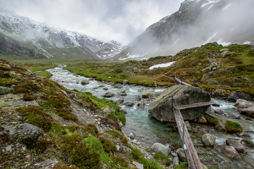 Die fließende Ziller, ein von Nebel umhülltes Bergpanorama mit einem türkis abwärtsfließendem Fluß