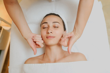 Obraz na płótnie Canvas Top view of Woman having curative facial cheecks massage.