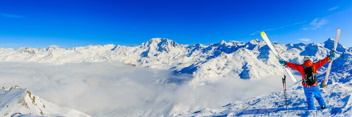 Ski in winter season, mountains and ski touring man on the top in sunny day in France, Alps above...