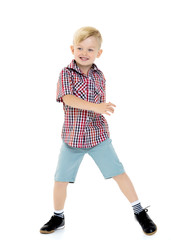 A cute little boy in a shirt and shorts.