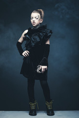 Beauty and fashion concept: Little girl wearing black outfit. Creative make up.
