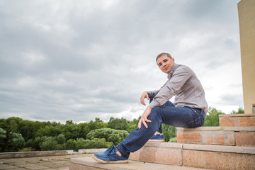 Obraz premium Portrait of handsome young man on the steps