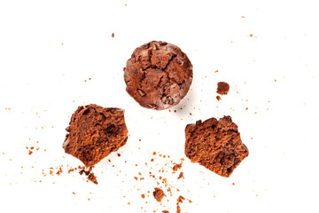 An overhead photo of messy chocolate muffins with crumbs, shot from above on a white background with a place for text, the texture of pastry