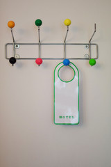 Empty hotel label hanging on hook at wall with copy space for text.