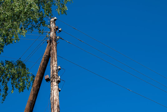 Old power line on a wooden pole. Transmission of electricity by wire in rural areas. Breakdown on high-voltage line and transformer. The telegraph pole.