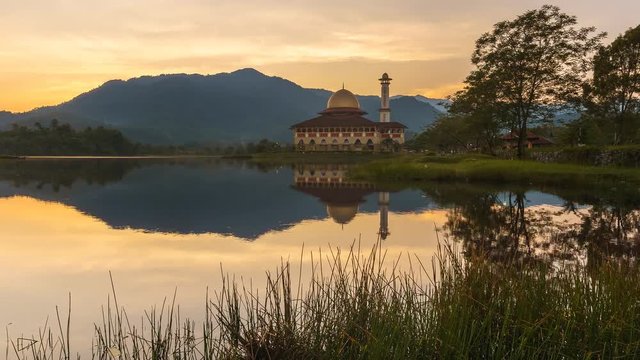 Beautiful sunrise with reflection of sunrise and the Darul Quran Mosque. Pan Right