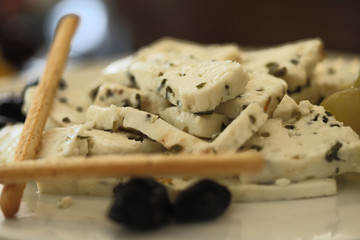 Delicious cheese snack on a white plate. Original and colorful design. The concept of proper nutrition. Cropped shot, close-up, horizontal, blurred
