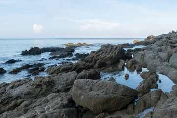 Fototapeta na wymiar beautiful seascape with motion of waves over rocks at Surin Beach, Phuket, Thailand