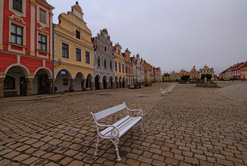 Naklejka premium Picturesque view of medieval square in Telc. Fountain with statue of st. Margaret, Plague Column. Authentic colorful houses around the square. A UNESCO world heritage site. Telc, Czech Republic