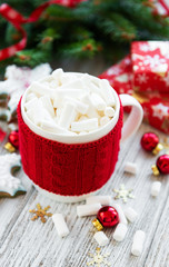 hot chocolate with marshmallows and gingerbread cookie on a old wooden table