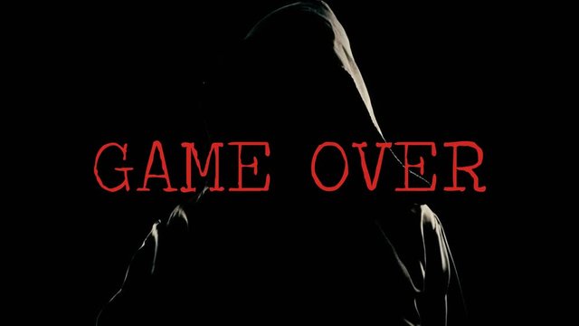 A faceless friar (a ghost, a ghoul or a madman) throwing an axe chopper in the air, with the distorted red text Game Over. Scary weird horror Halloween clip.
