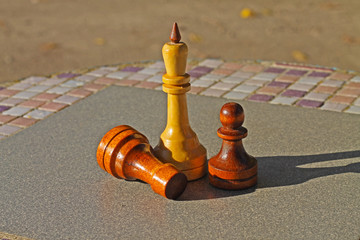 Three chess pieces on the park table.