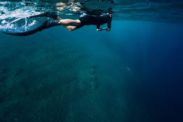 Fototapeta na wymiar Freediver in wetsuit swimming in the ocean