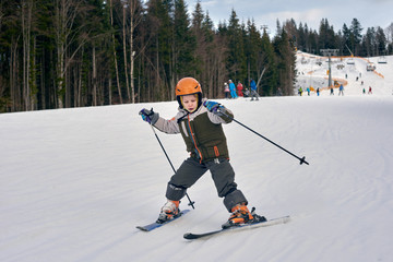 Active young boy skiing in mountains and enjoying vacation