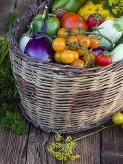 Fresh vegetables in a basket on a rustic wooden table with space for text.