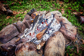 burning firewood on small campire surrounded by stones