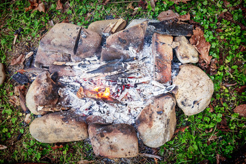 burning firewood on small campire surrounded by stones