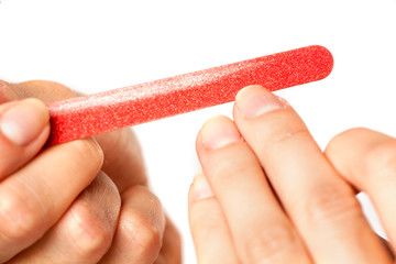 closeup of woman filing her nails on white background