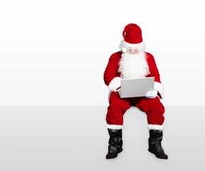 santa claus watching laptop and sitting on blank panel