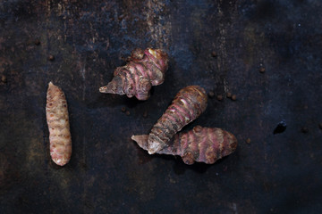 Topinambur, słonecznik bulwiasty na ciemnym tle.