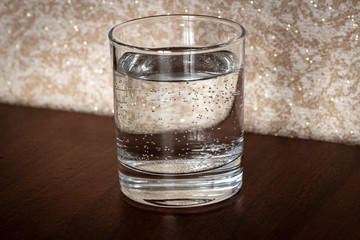 A glass of pure mineral water is on the table.