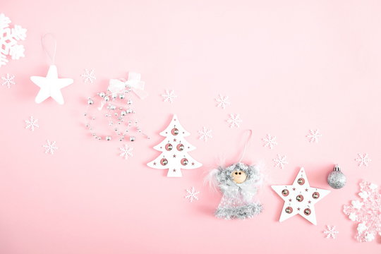 Christmas elegant composition. Xmas silver and white decorations on pastel pink background. Christmas, New Year, winter concept. Flat lay, top view, copy space 