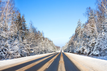 winter landscape with asphalt road and forest