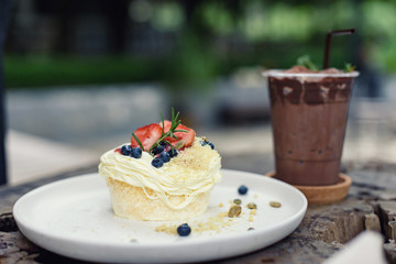 Strawberry and blueberry cake on top pumpkin seed with iced cocoa.