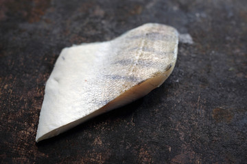 Ryba. Składniki potrawy, filet z sandacza na ciemnym tle. © foodandcook