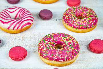 Donuts and macaroons on a wooden background