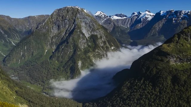 Timelapse of beautiful scenery from Mackinnon Pass on Milford Track, one of the most beautiful hikes in the world located in Fiordland, New Zealand, on a sunny summer day.