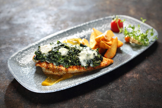 Grillowany filet z kurczaka z sosem szpinakowym, podany na  brzoskwiniowym puree z dodatkiem pieczonych ziemniak&oacute;w.
