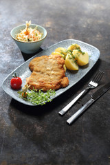 Danie obiadowe. Kotlet smażony w panierce, ziemniaki z wody, surówka z białej kapusty.