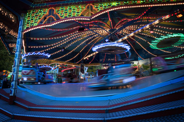 fast  funfair ride carousel at the christmas market, long exposure with blurred motion, abstract background, copy space © Maren Winter