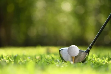 Foto op Plexiglas Golf Golfbal op groen gras klaar om op golfbaanachtergrond te worden geslagen